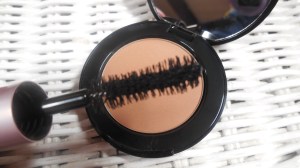 Close up of mascara wand and bronzer color